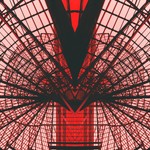 Abstract view of a red geometric architectural structure, showcasing modern design and symmetry.